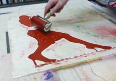 ein Tango- Holzschnitt wird mit roter Farbe eingewalzt